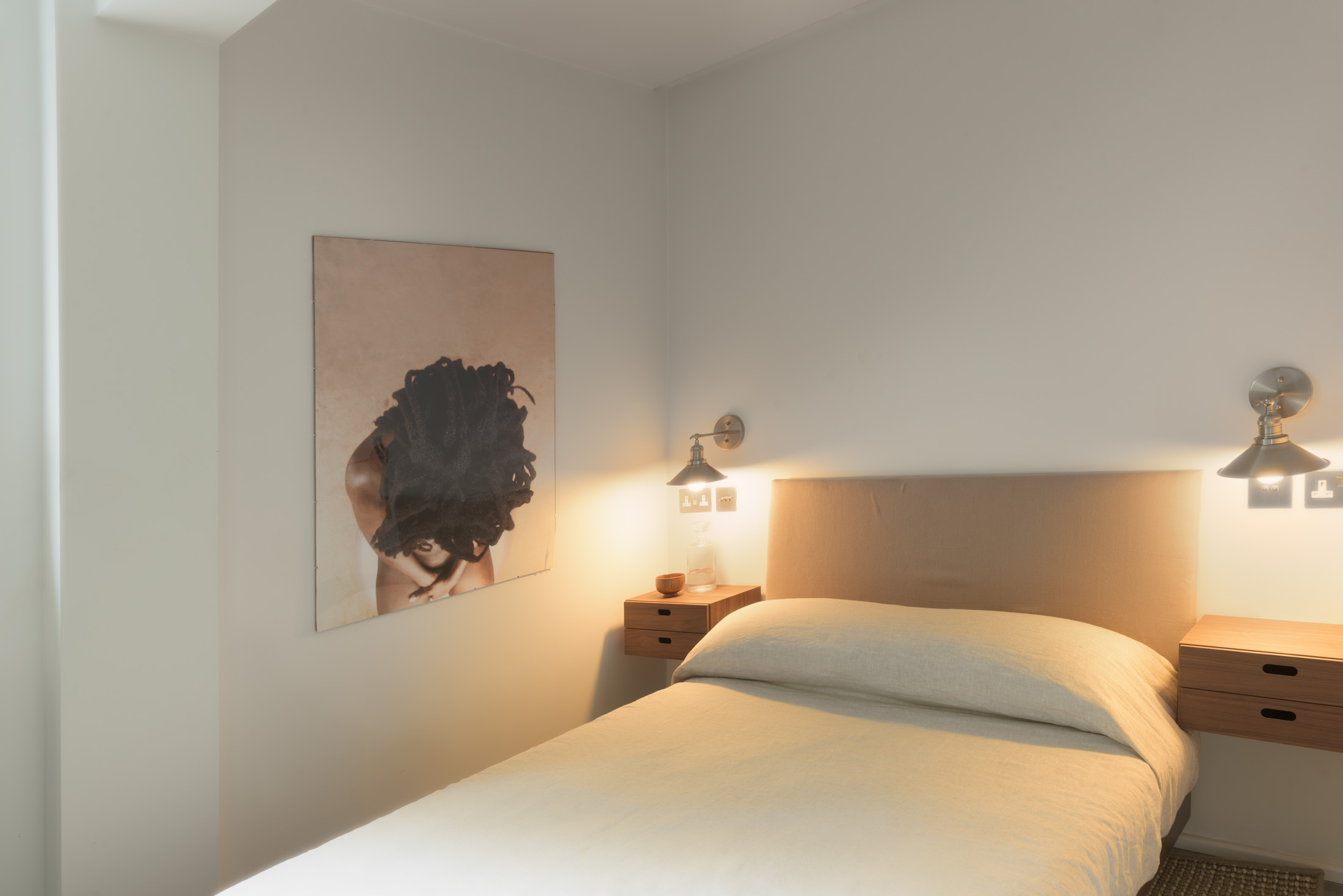 Second bedroom with warm lighting and photographic art
